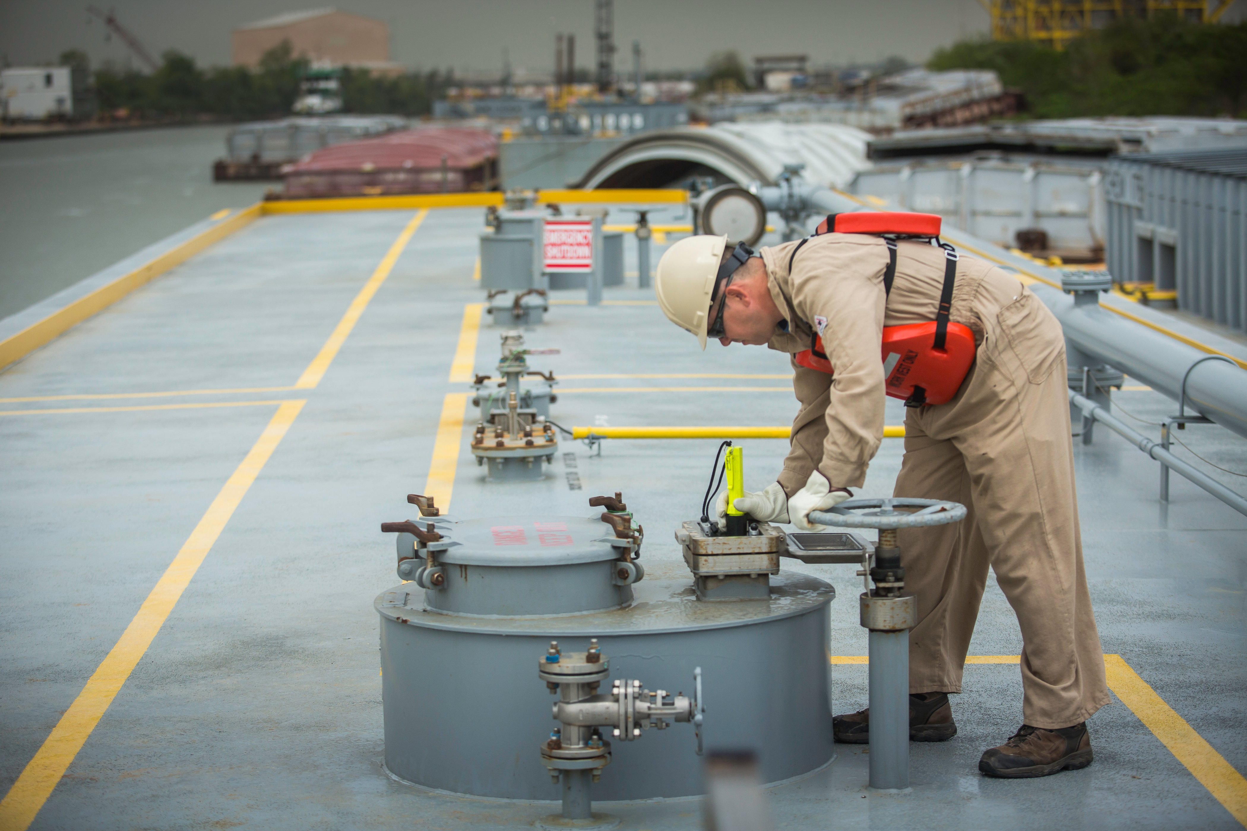 A tankerman monitors product levels during a barge transfer